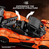 Orange and black model car with open cockpit cover and rear cover, showcasing mechanical details.